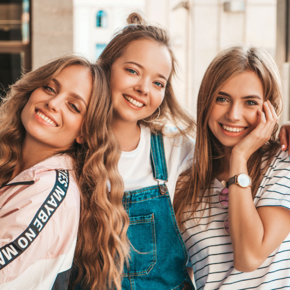 three young women smiling after treatment at space city orthodontist in houston tx